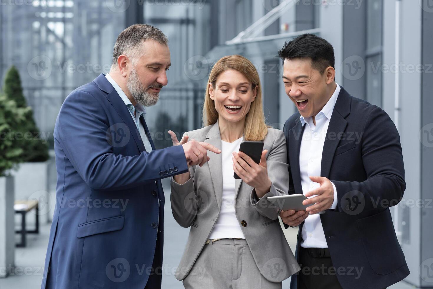 Tres eso especialistas empresarios fuera de oficina edificio acecho en colegas teléfono, contento y sonriente descansando en descanso desde trabajo foto