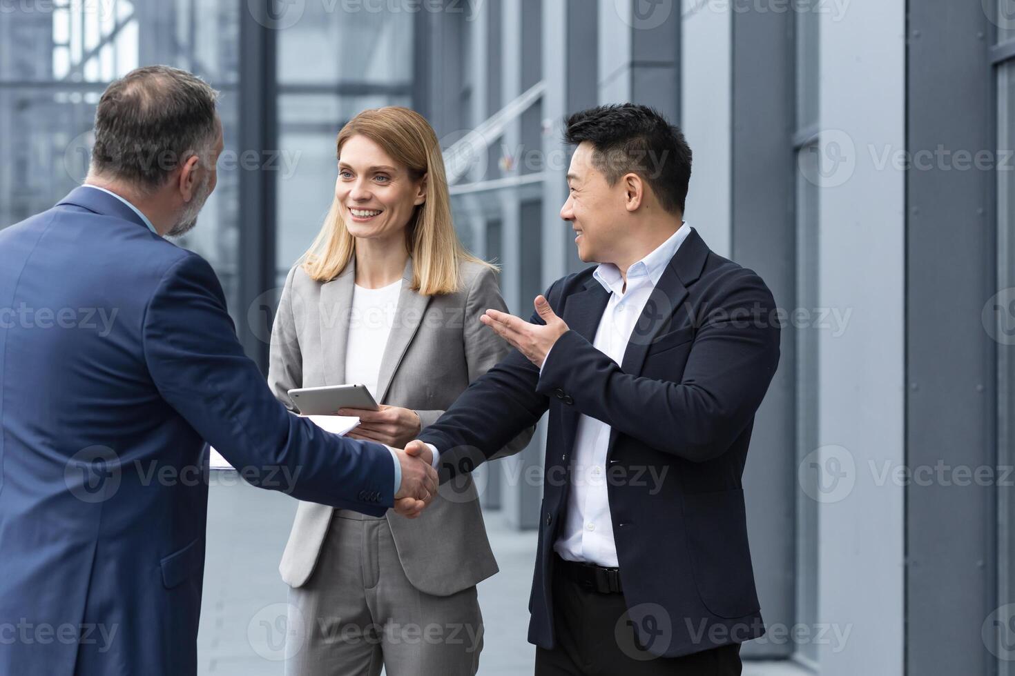 Three experienced managers team leaders, meet and get to know from outside the office team, diverse group of entrepreneurs shake hands men, introduce new colleague photo
