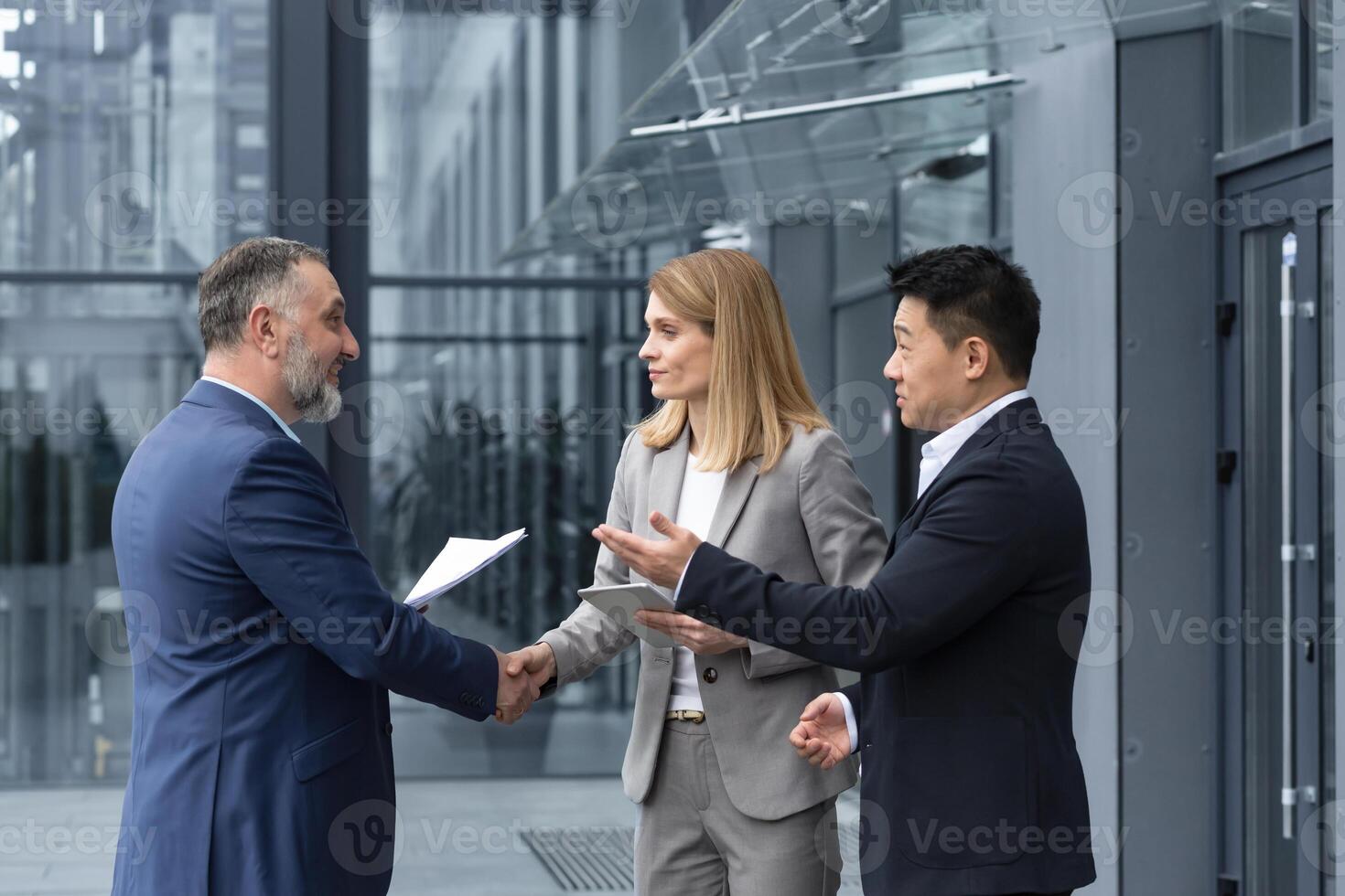 Three experienced managers team leaders, meet and get to know from outside the office team, diverse group of entrepreneurs shake hands men, introduce new colleague photo