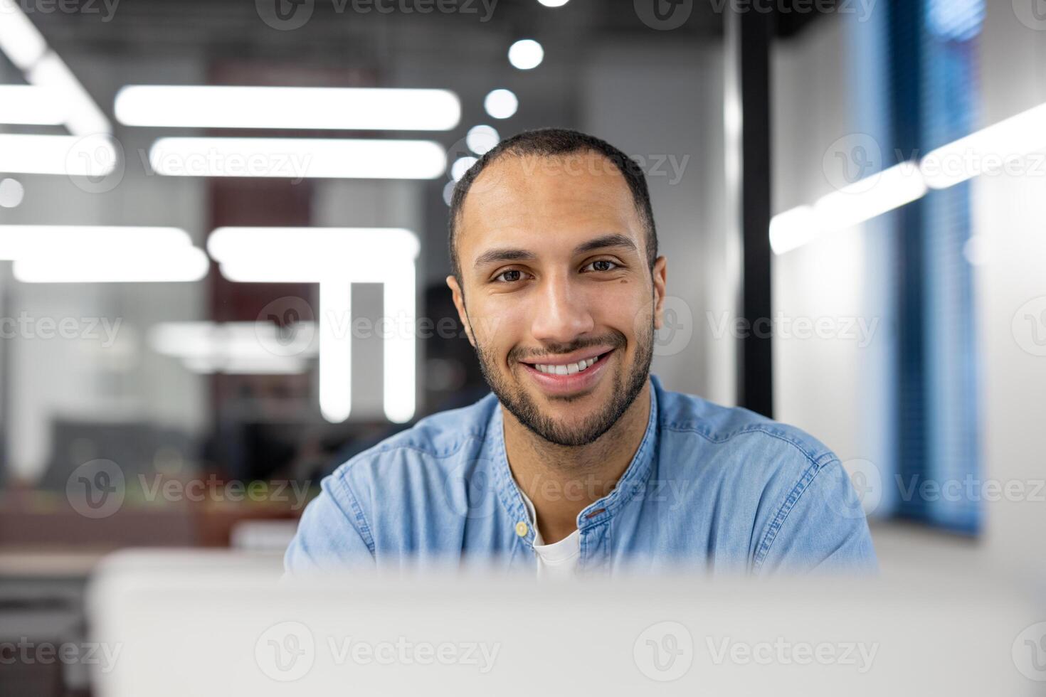 Focused professional working on a computer in a brightly lit modern office environment, showing productivity and dedication. photo