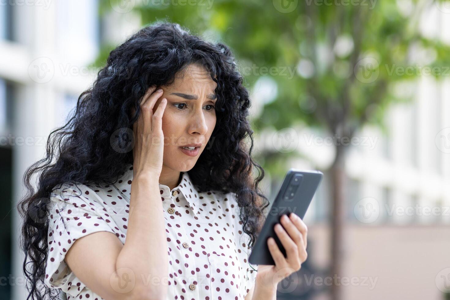 triste decepcionado mujer recibido en línea notificación con malo Noticias en su teléfono, mujer de negocios caminando fuera de oficina edificio, utilizando solicitud en teléfono inteligente, leyendo social medios de comunicación insatisfecho. foto