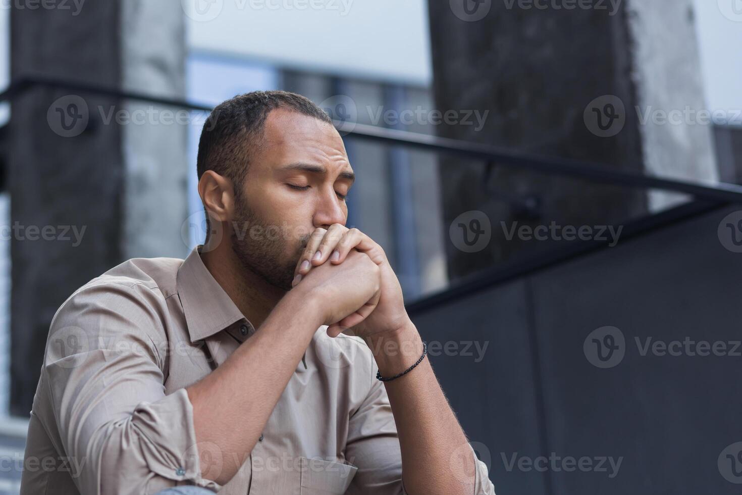 Close-up photo portrait of upset office worker fired businessman in depression, man with closed eyes sitting on stairs of office building outside
