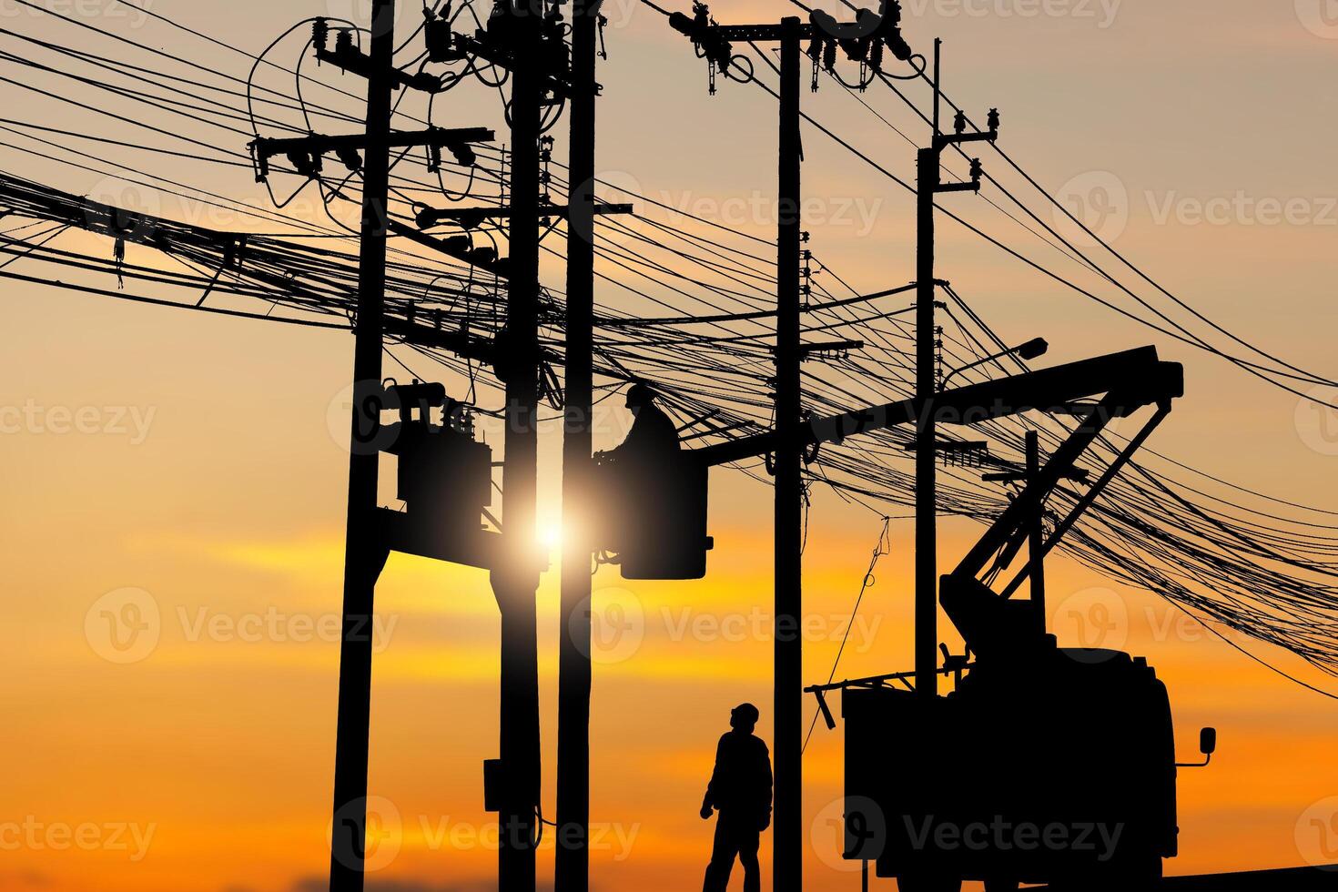 Silhouette of Electrician officer climbs a pole and uses a cable car to maintain a high voltage line system, Shadow of Electrician lineman repairman worker at climbing work on electric post power pole photo