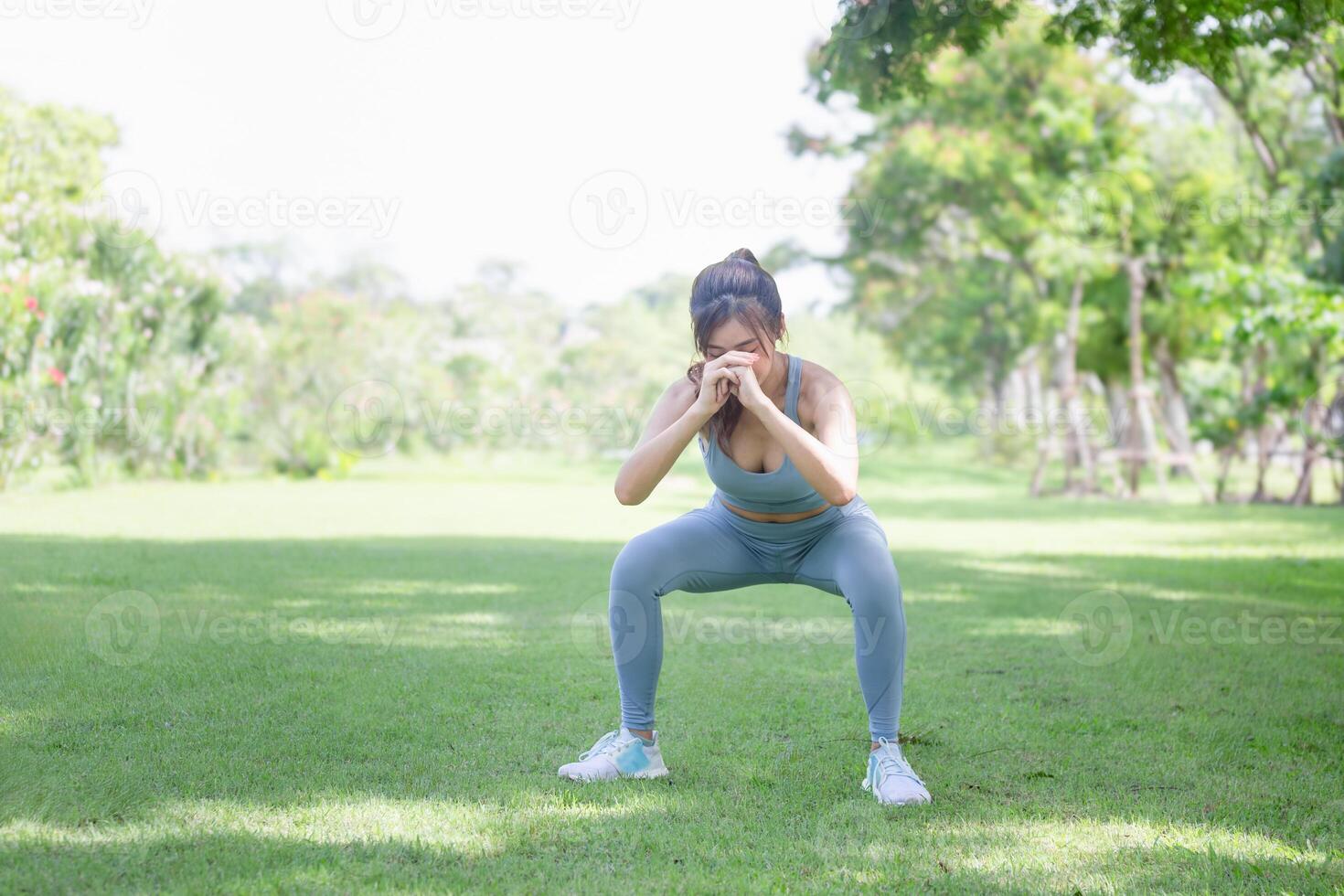 Sport woman warming up in the park, Fitness woman doing stretching exercises outdoors photo