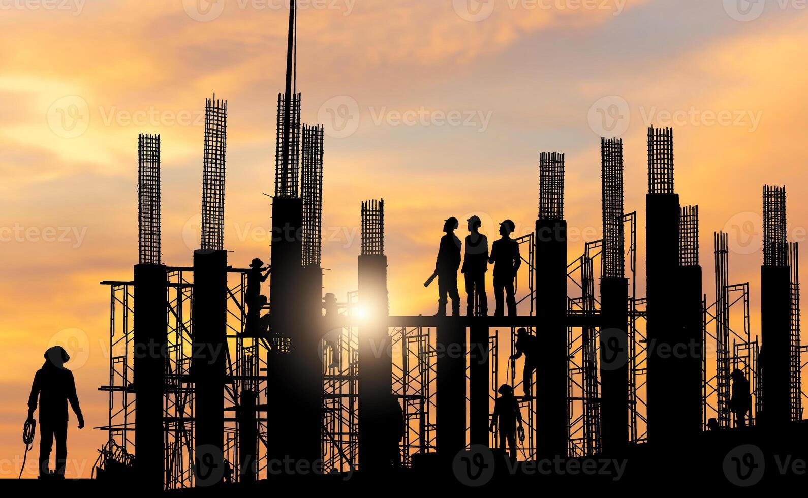 Silhouette of Engineer and worker checking project at building site background, construction site at sunset in evening time photo