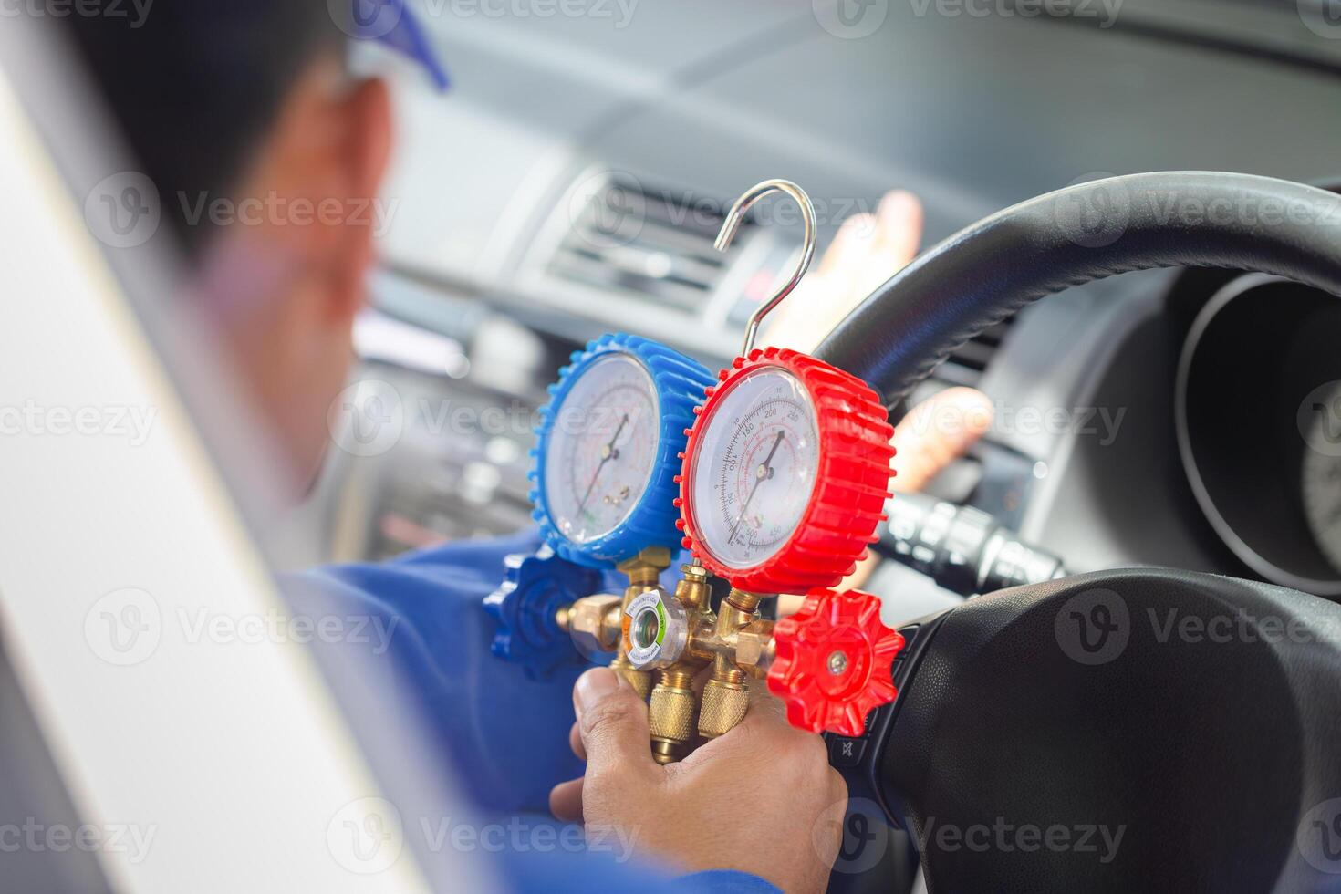 Repairman holding monitor tool to check and fixed car air conditioner system, Technician check car air conditioning system refrigerant recharge, Air Conditioning Repair photo