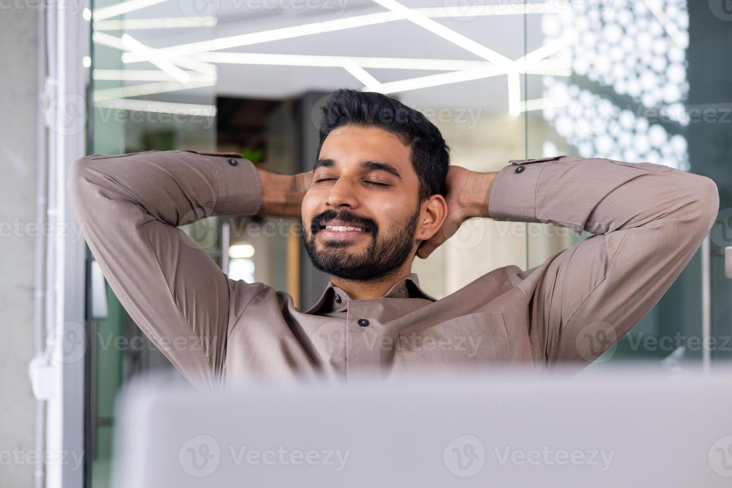 Businessman resting close up well done successfully completed portrait, man with hands behind head with eyes closed smiling, financier accountant working with laptop inside office. photo