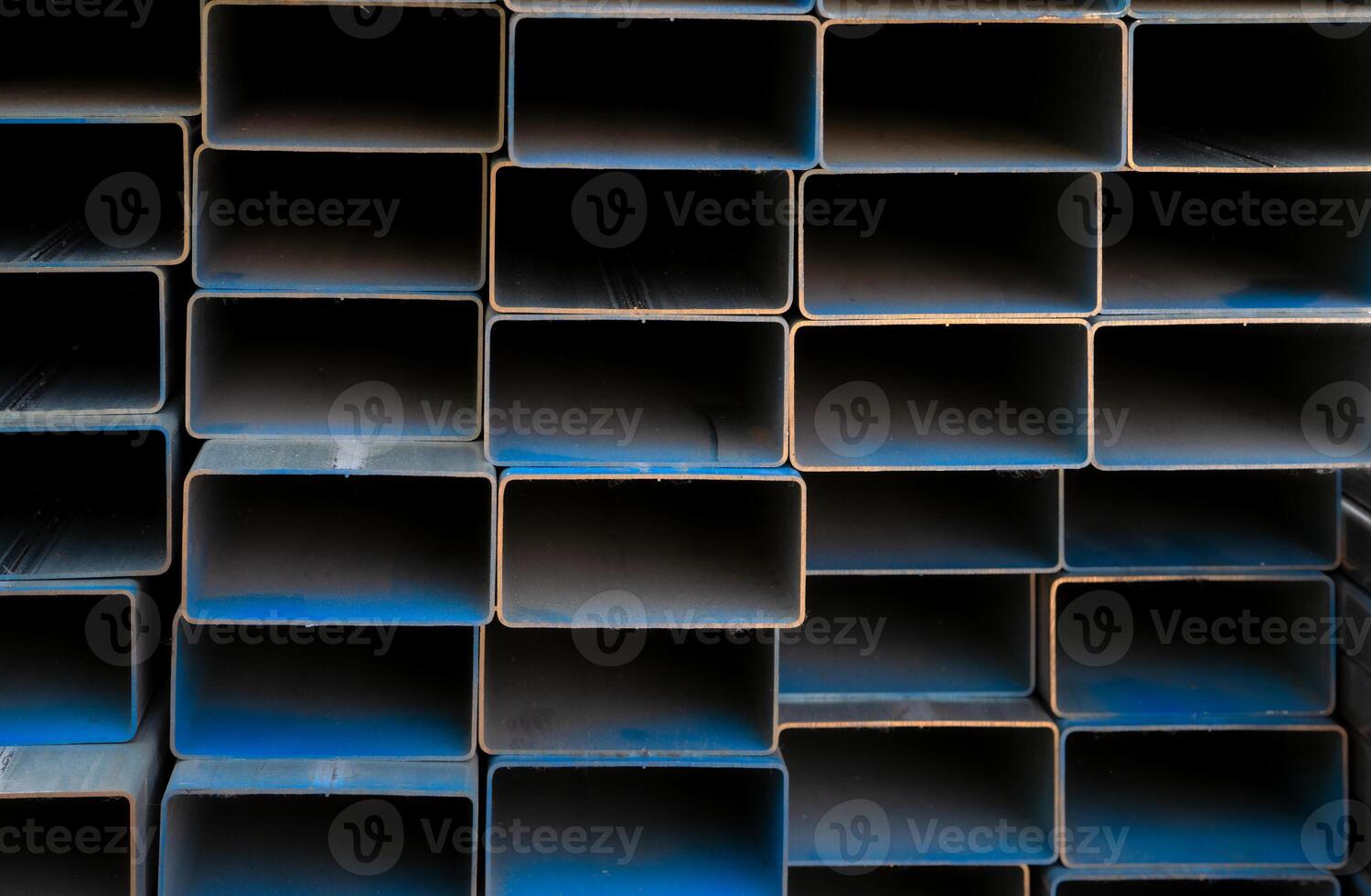 Industrial warehouse stock of rectangular metal pipes for building and construction supplies. Stack of steel pipes. Iron materials for construction and infrastructure projects. Steel tubing storage. photo
