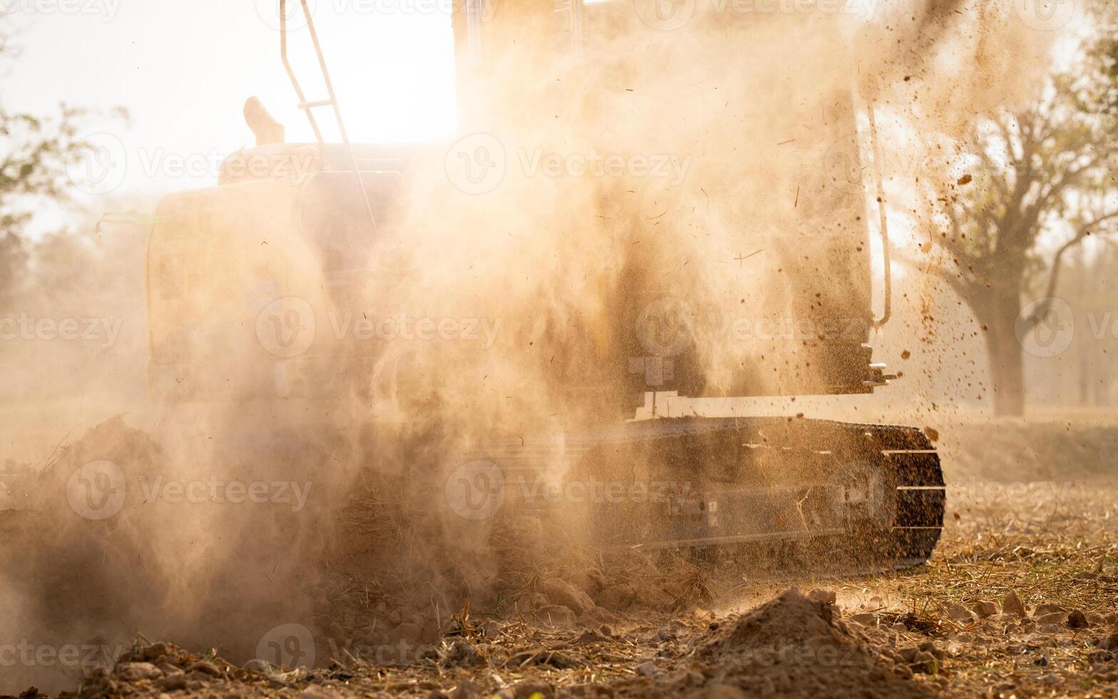 Backhoe working by digging soil at construction site. Excavator working on demolition site with dust in the air. Excavating machine. Earth moving machine. Excavation vehicle. Construction business. photo