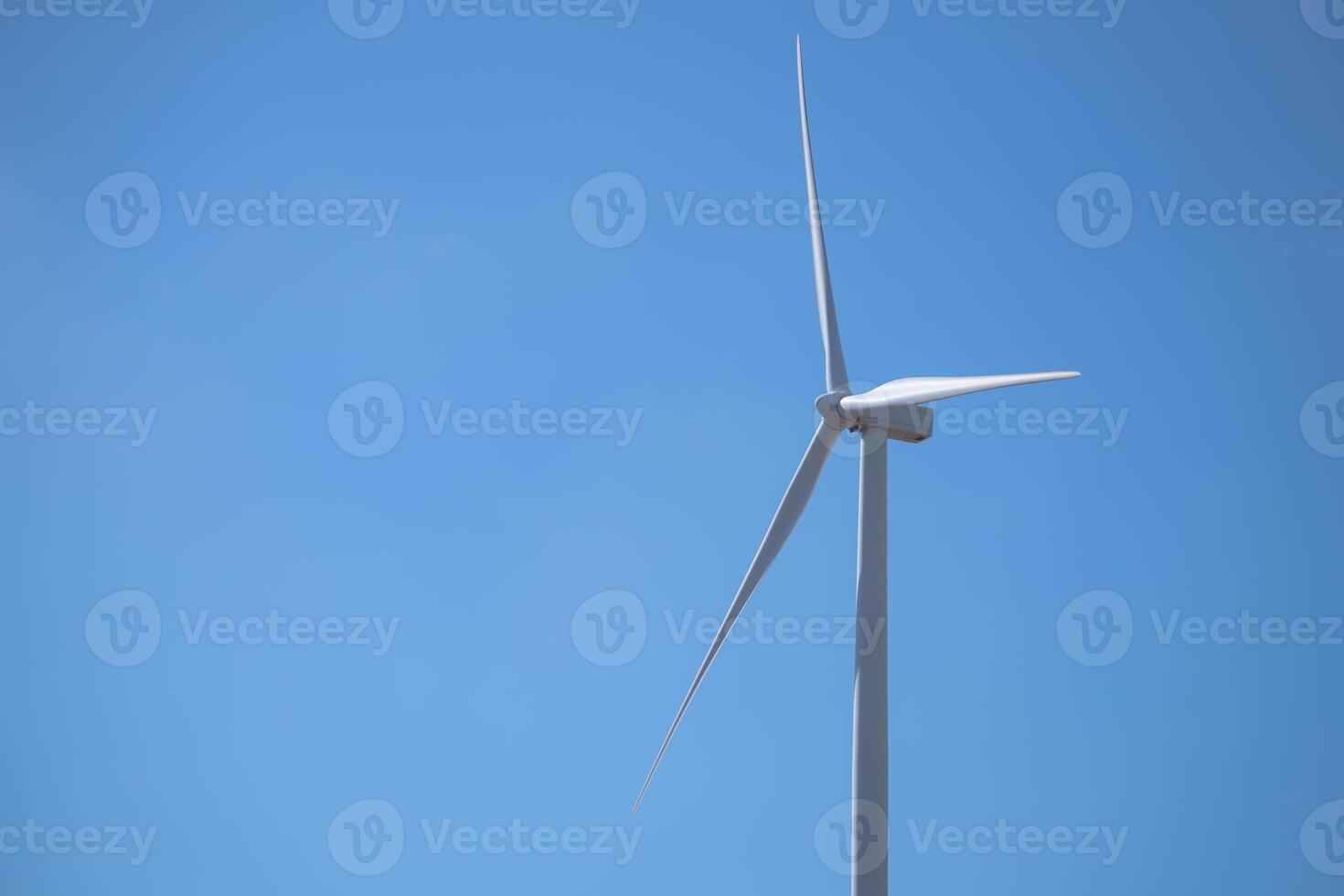 Wind turbine is standing tall in blue sky, Wind energy. Wind power. Sustainable, renewable energy. Wind turbine generate electricity. Sustainable resources. Green technology for energy sustainability. photo