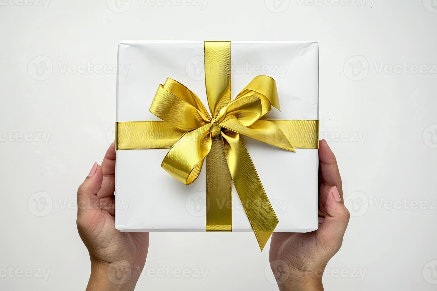 Chic hand holding white gift box with gold ribbon isolated on solid background. Stock photo. photo