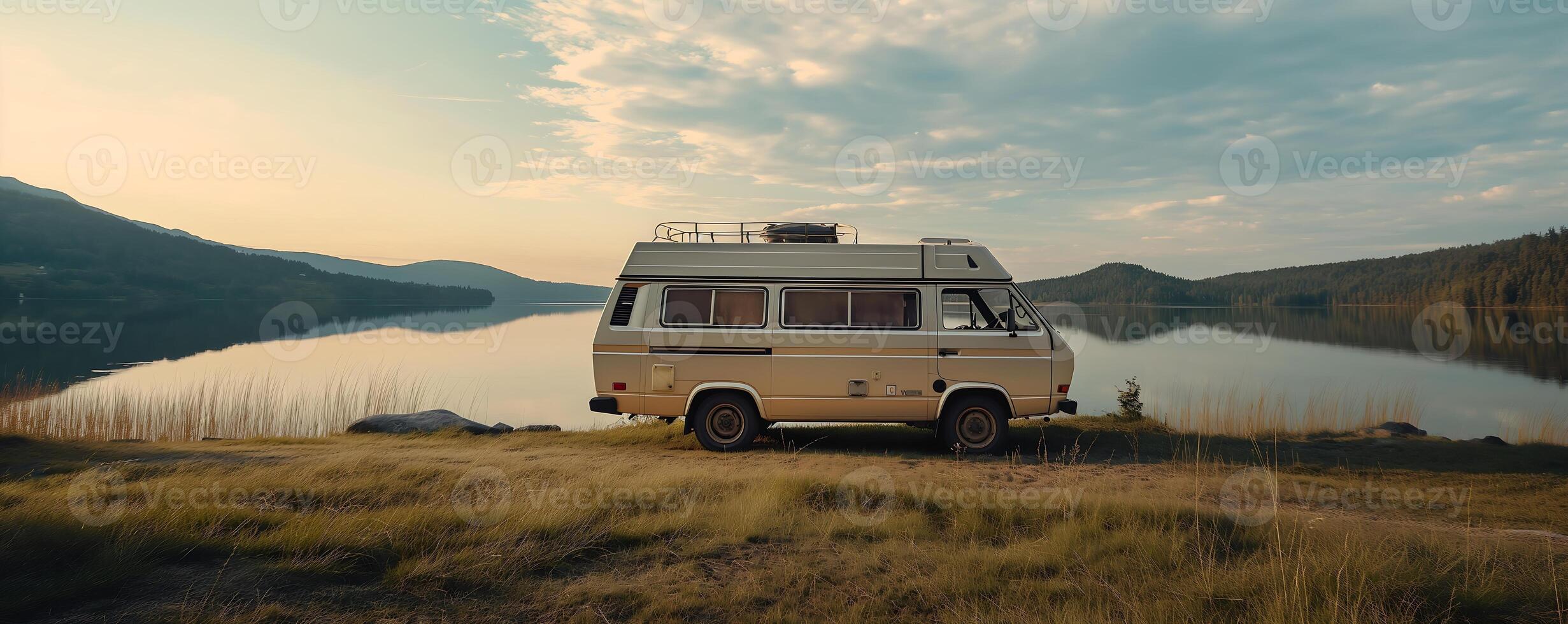 travel van surrounded by well-maintained grass and a calm lake photo