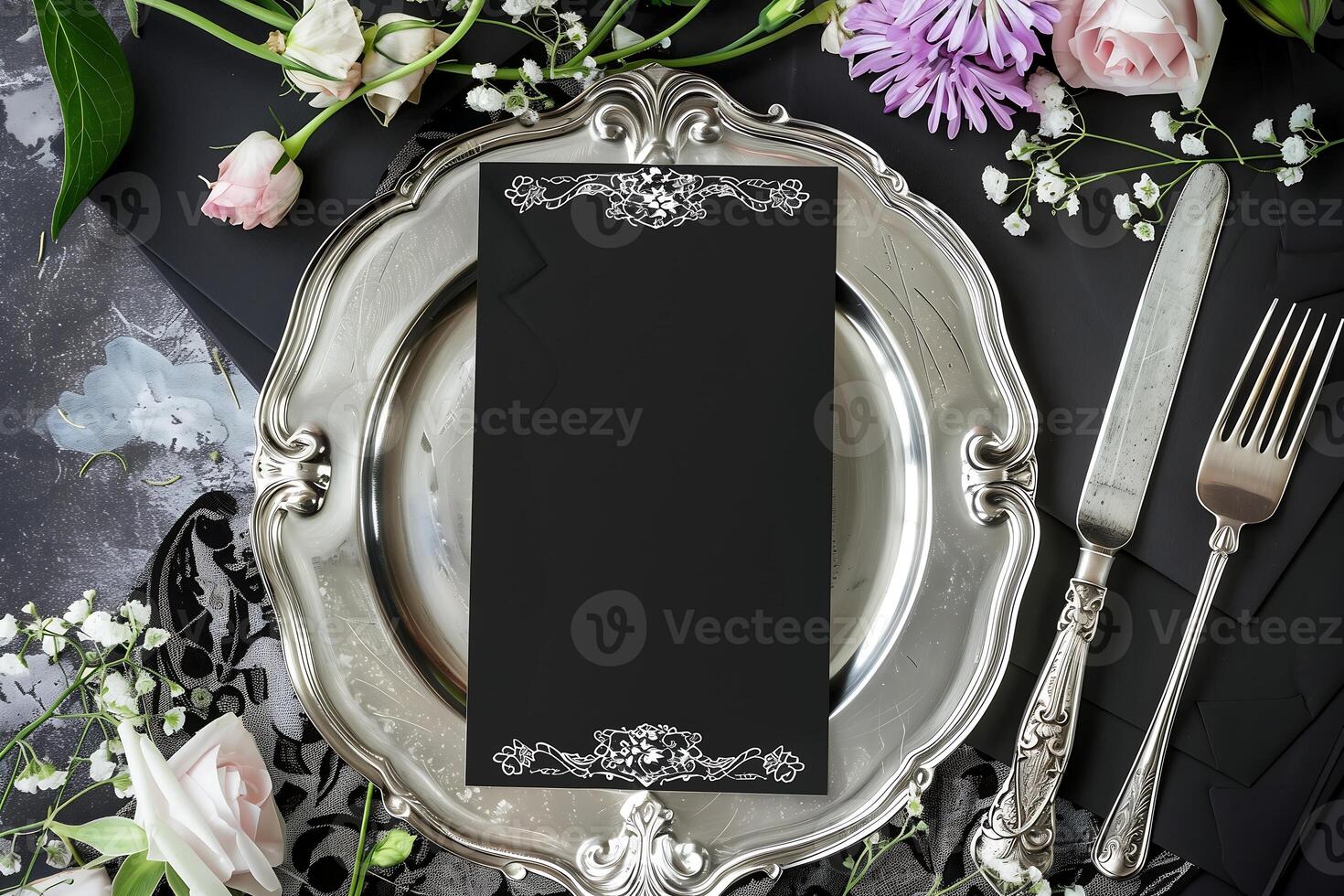 elegant blank menu placed on a beautiful silver plate, with a fork and knife beside it surrounded by fresh flower decorations photo