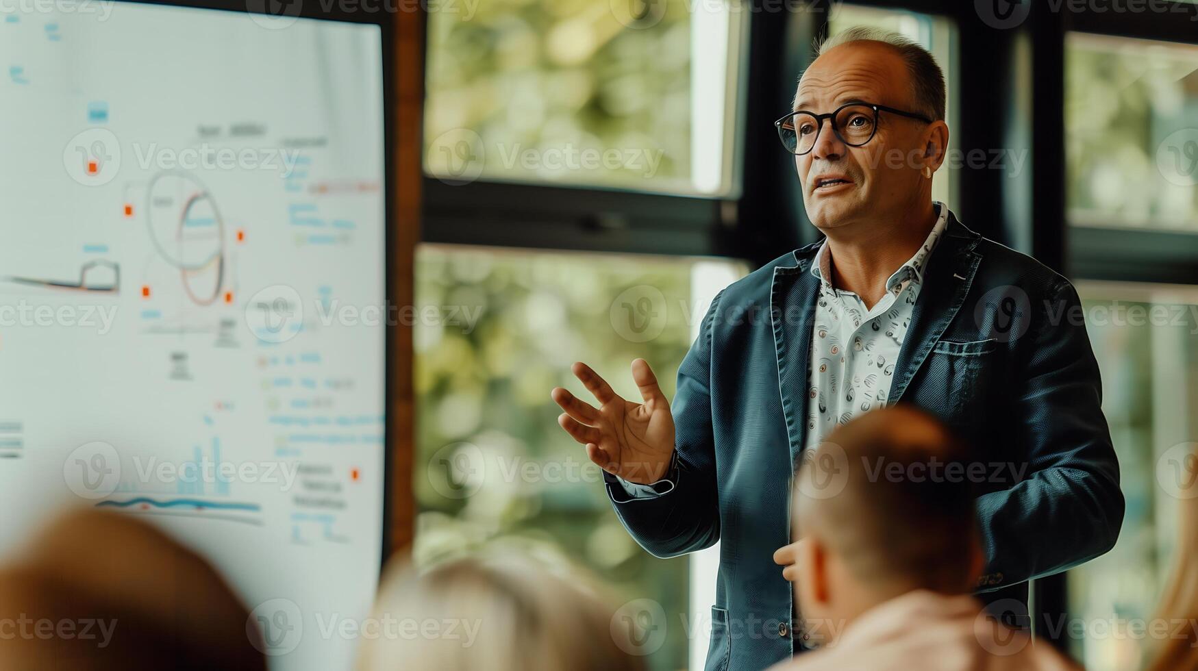 male speaker standing in front of a flipchart in a conference room delivering a training session to a group of businessmen photo