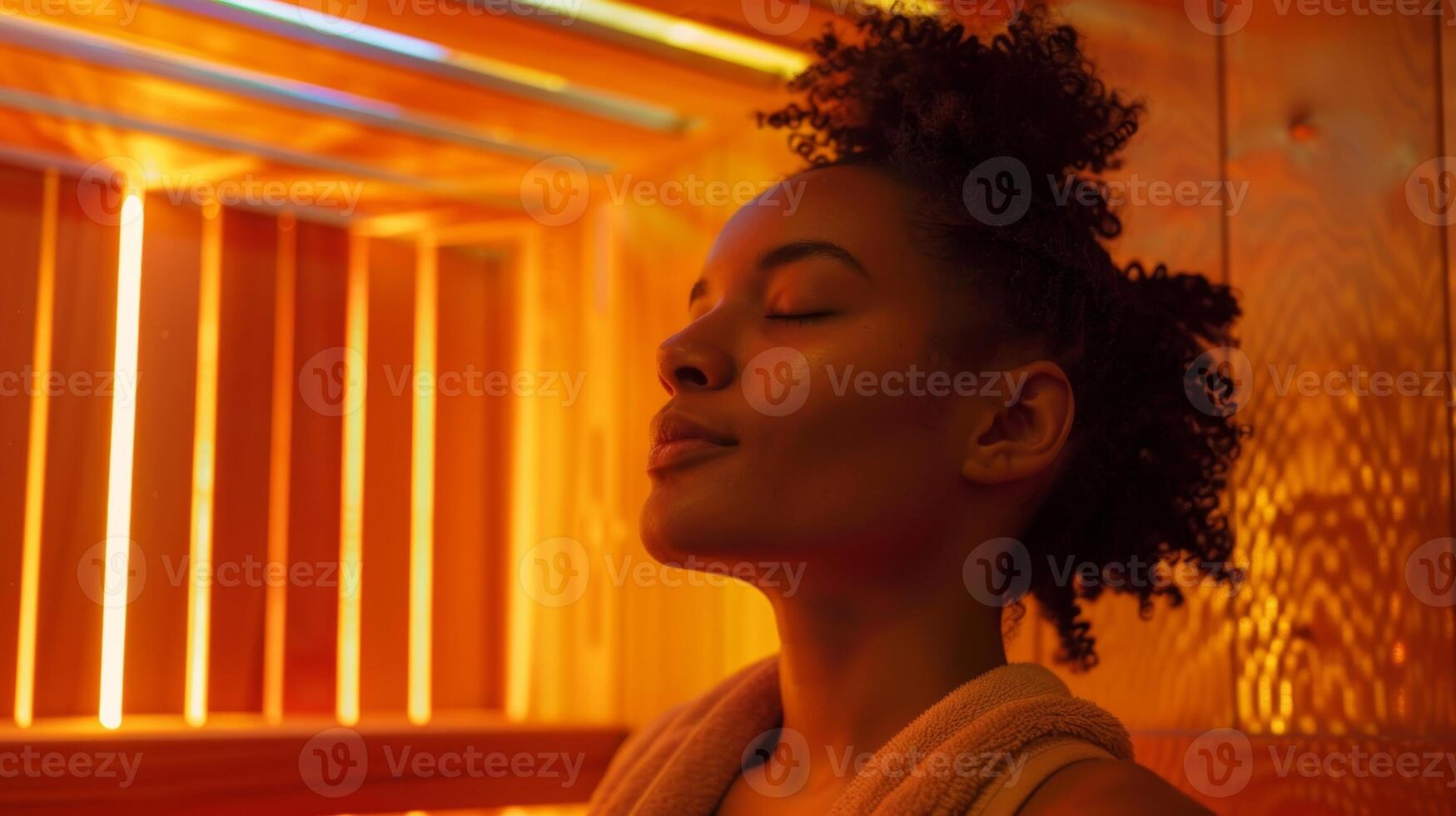 A woman peacefully meditates in the sauna surrounded by the soothing warmth and soft music. photo