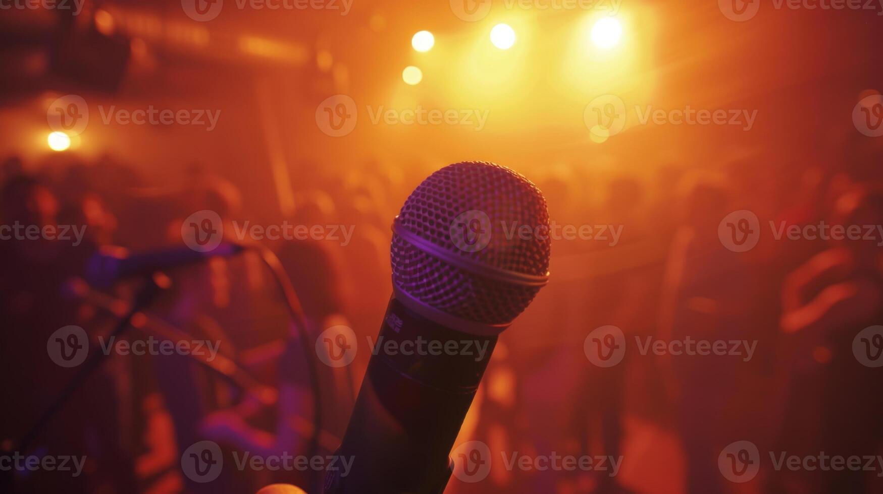 A brightly lit stage with a microphone as people gather around to sing their hearts out with smiles on their faces photo