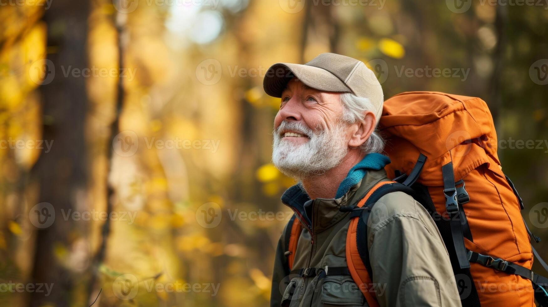 A senior man pausing to take a deep breath and fill his lungs with the crisp clean air as he explores a wooded trail photo