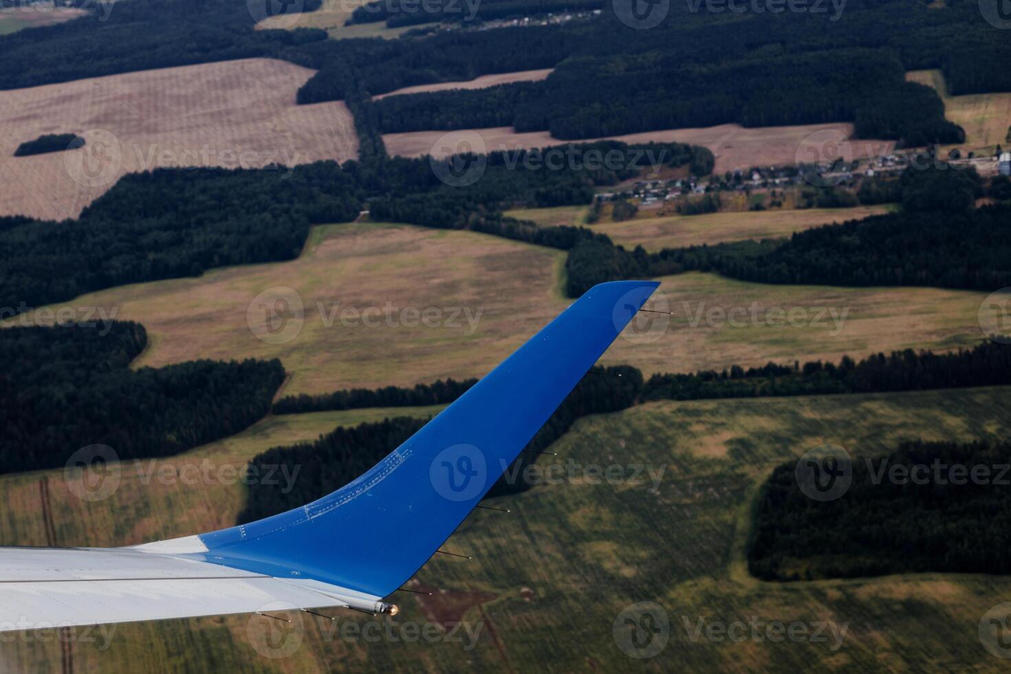 aerial view of landscape with view of aircraft wing photo