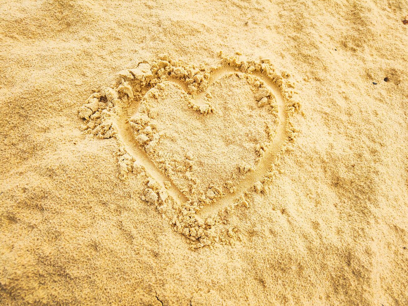 photography of draw love on the beach sand in summer photo