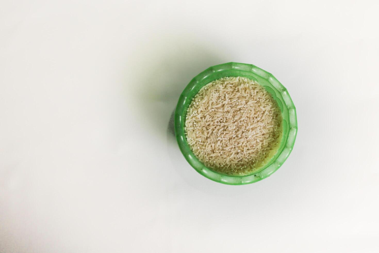 photography of rice in a plastic container on an isolated white background photo