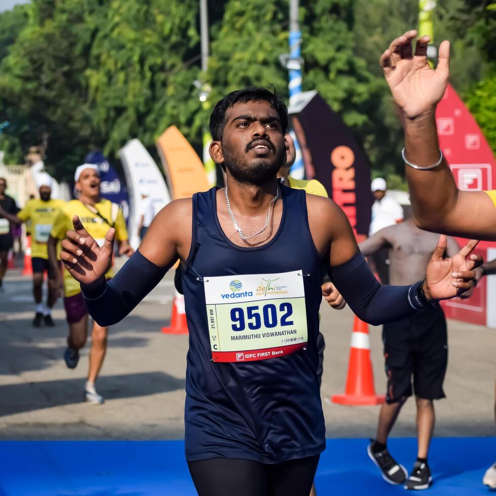 New Delhi, India - October 15 2023 - Vedanta Delhi Half Marathon race after covid in which marathon participants about to cross the finish line, Delhi Half Marathon 2023 photo