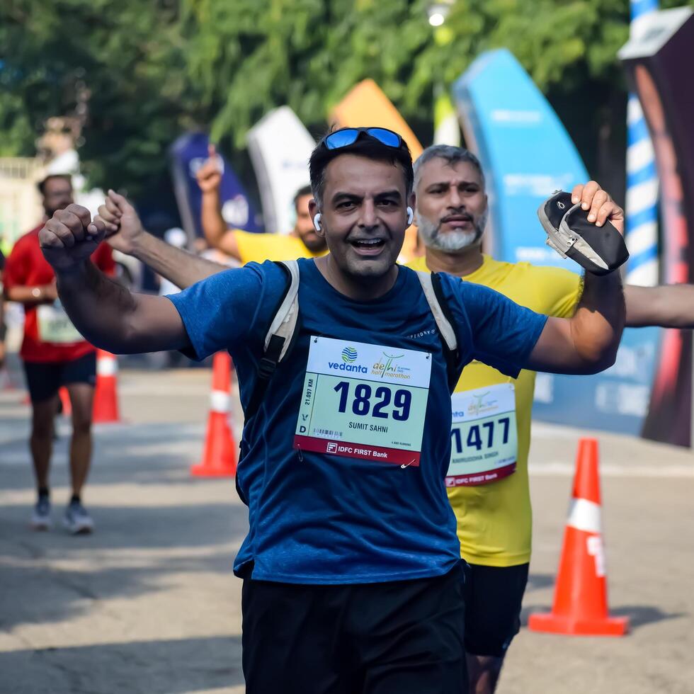 New Delhi, India - October 15 2023 - Vedanta Delhi Half Marathon race after covid in which marathon participants about to cross the finish line, Delhi Half Marathon 2023 photo