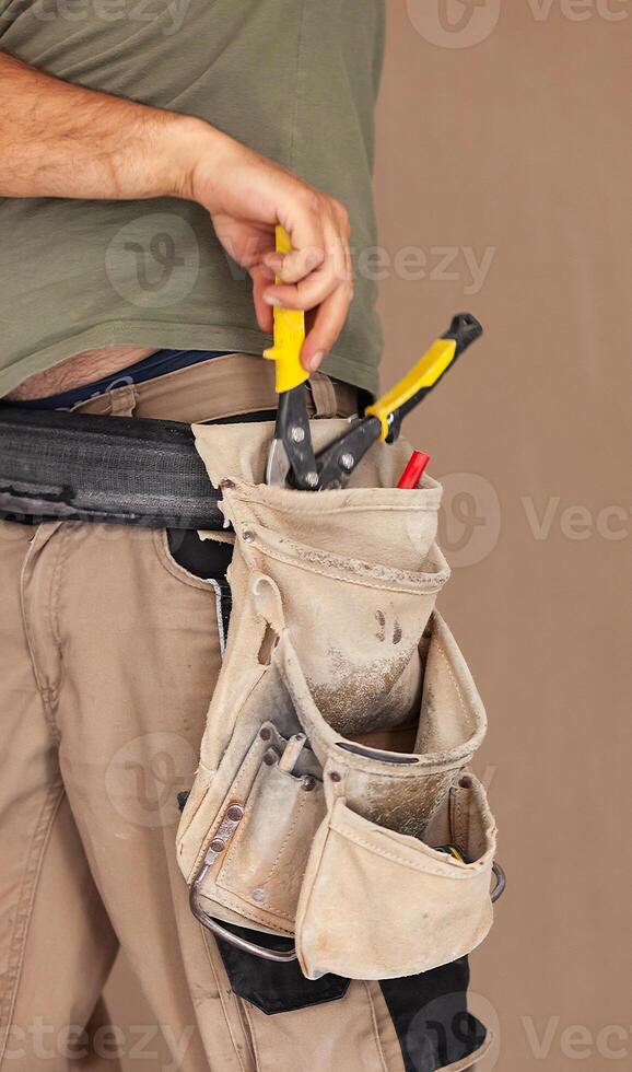 Worker uses tool belt, authentic and real moment. photo