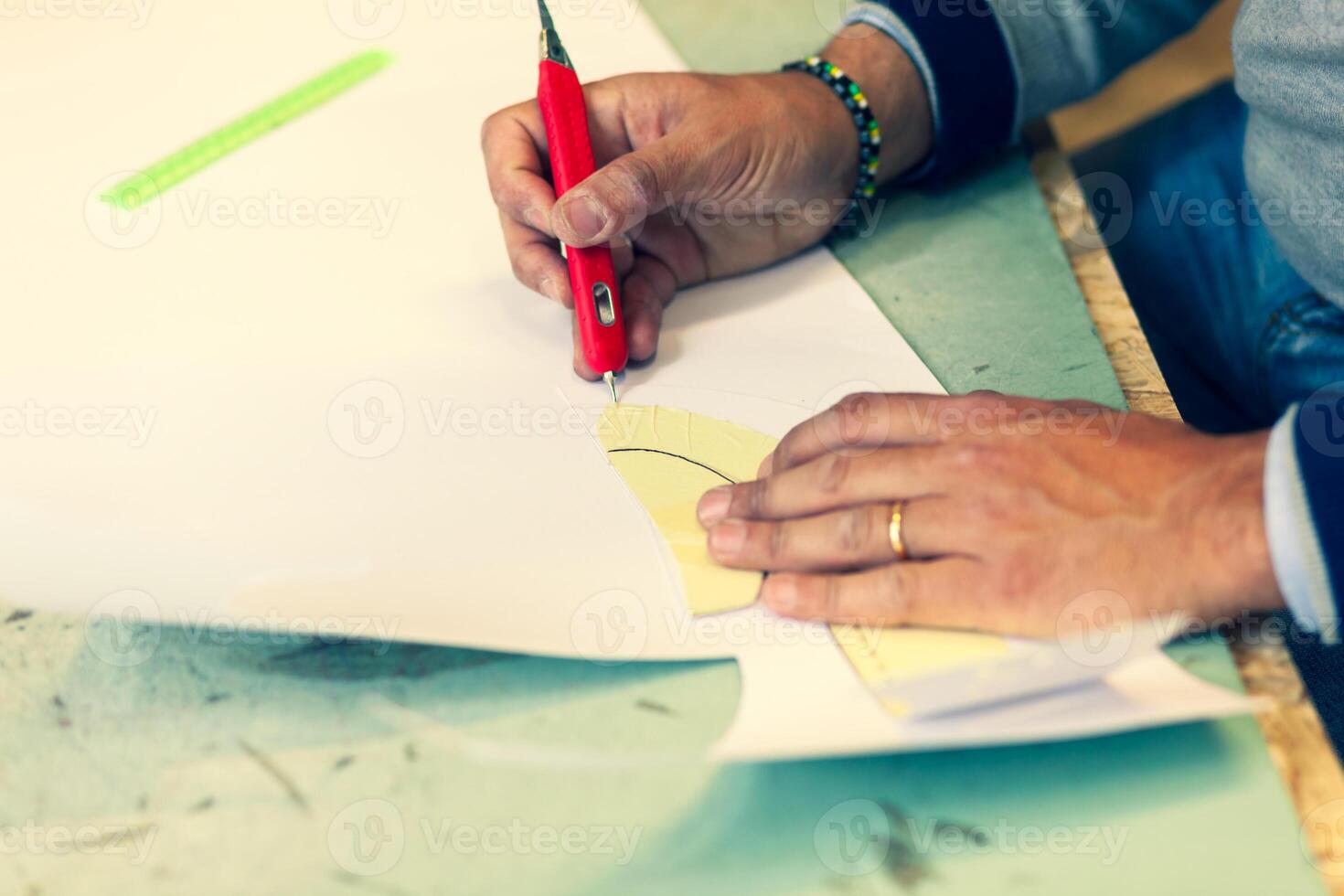 Shoe designer working with paper models for leather cutting. photo