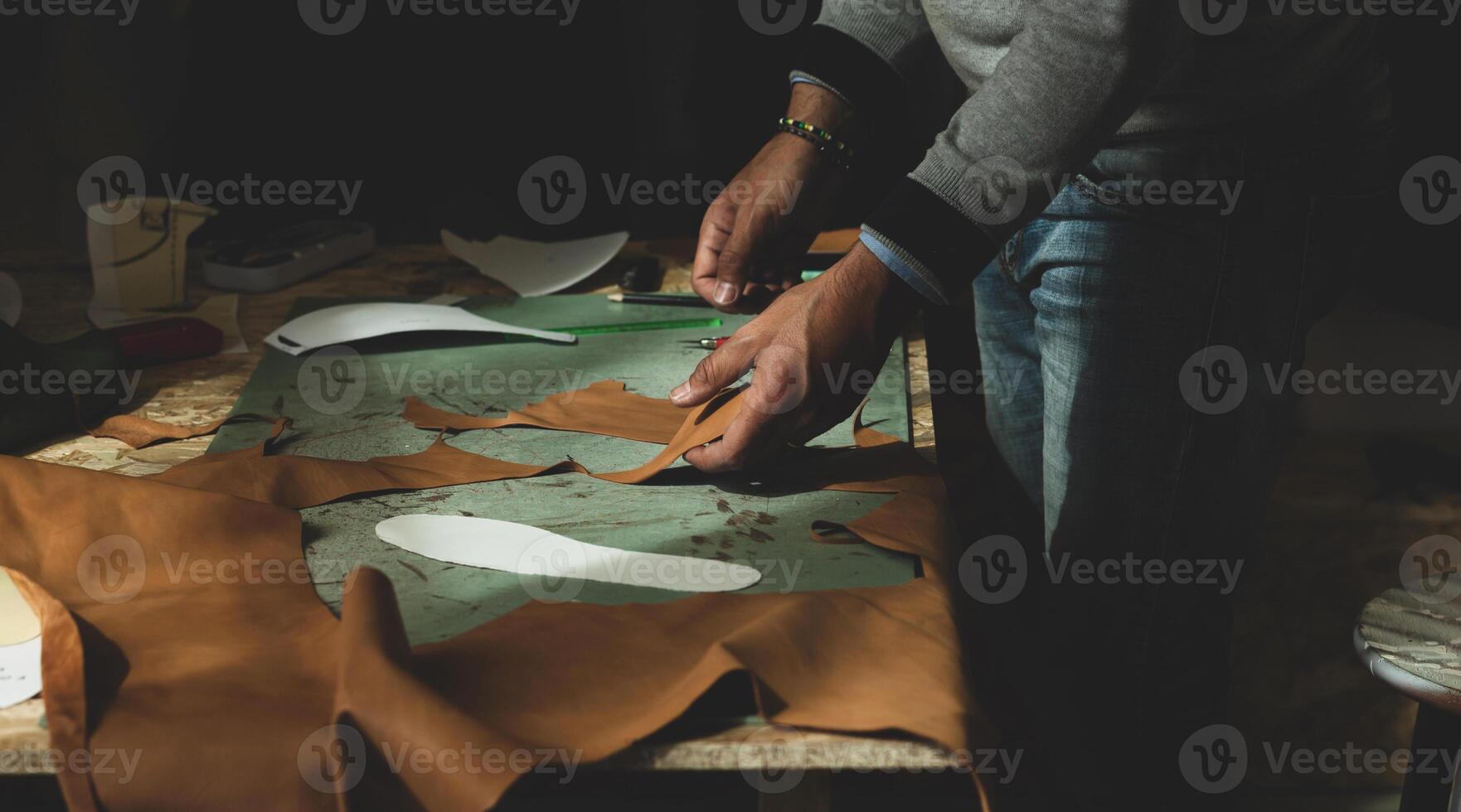 Shoemaker cutting leather photo