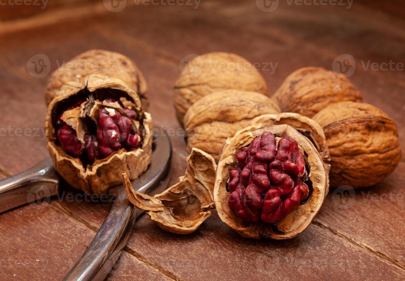 Red Danube Walnuts with silver nutcracker on wooden background photo