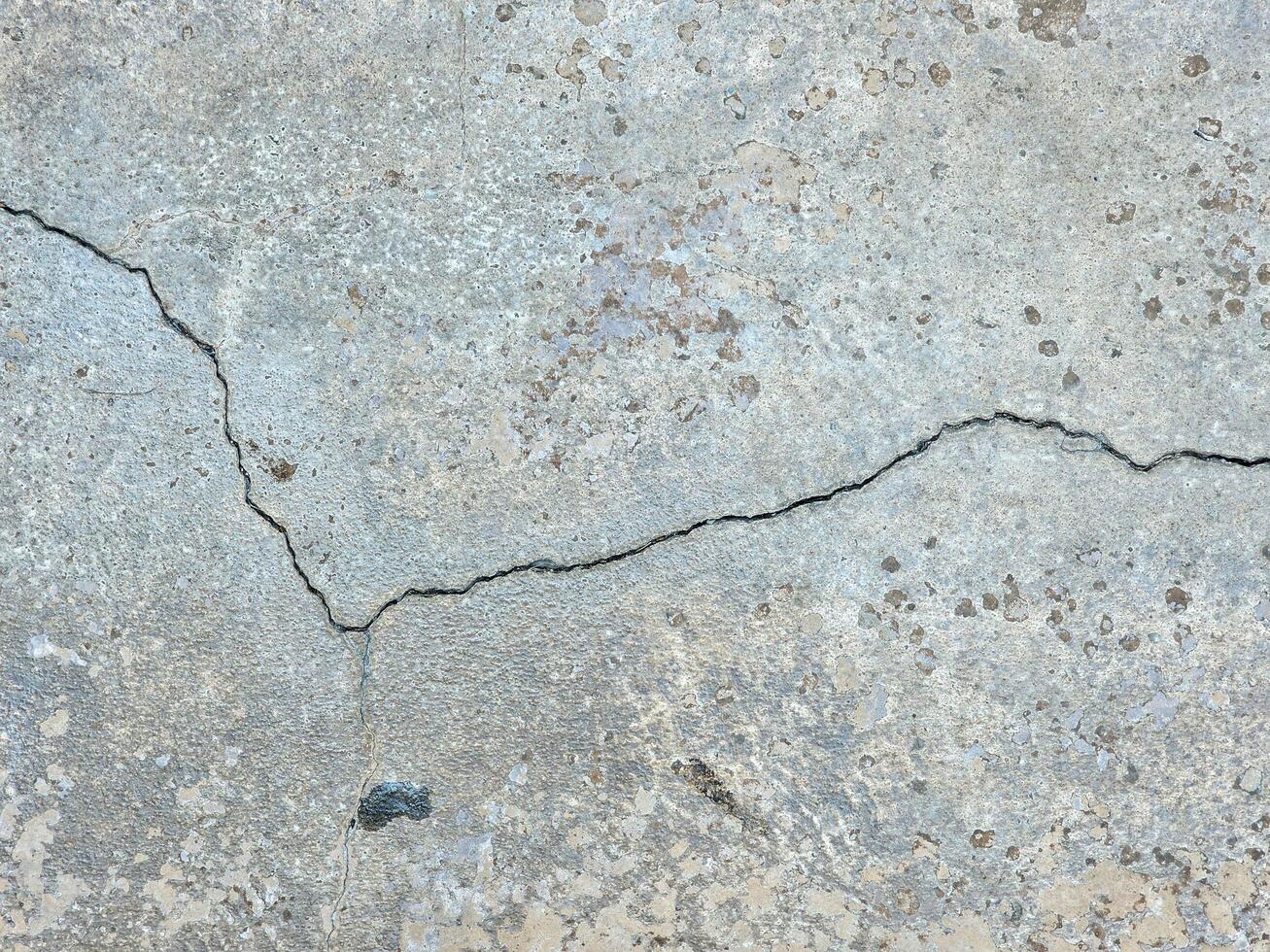 cracked concrete wall or road surface with gray cement surface as background photo