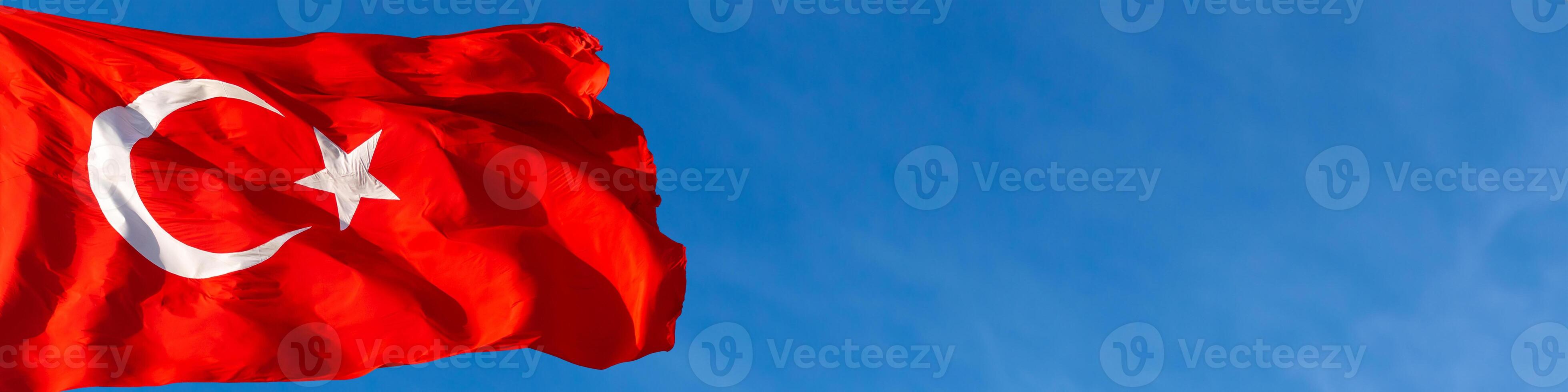 Banner of Turkish Flag isolated on blue sky background. National holidays of Turkiye concept. photo