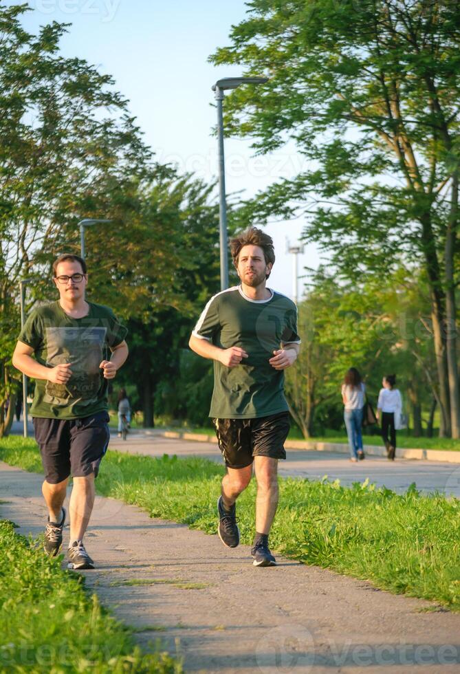 Two friends running with green t-shirt in park photo