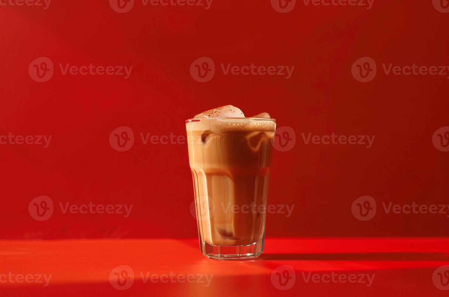 Minimalist glass glass of cold latte, sunlight on red background photo
