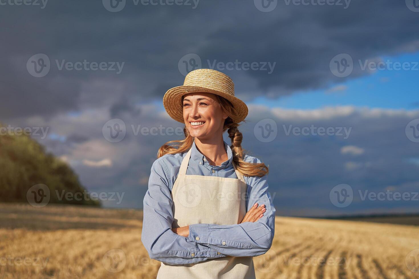 Woman farmer straw hat apron standing farmland smiling Female agronomist specialist farming agribusiness Happy positive caucasian worker agricultural field photo