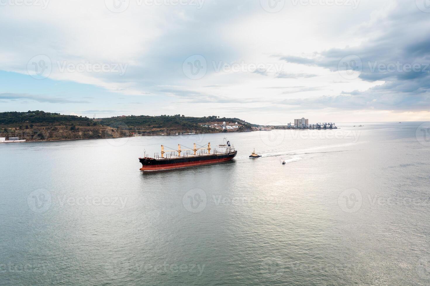 Container ship and small boat in calm sea photo