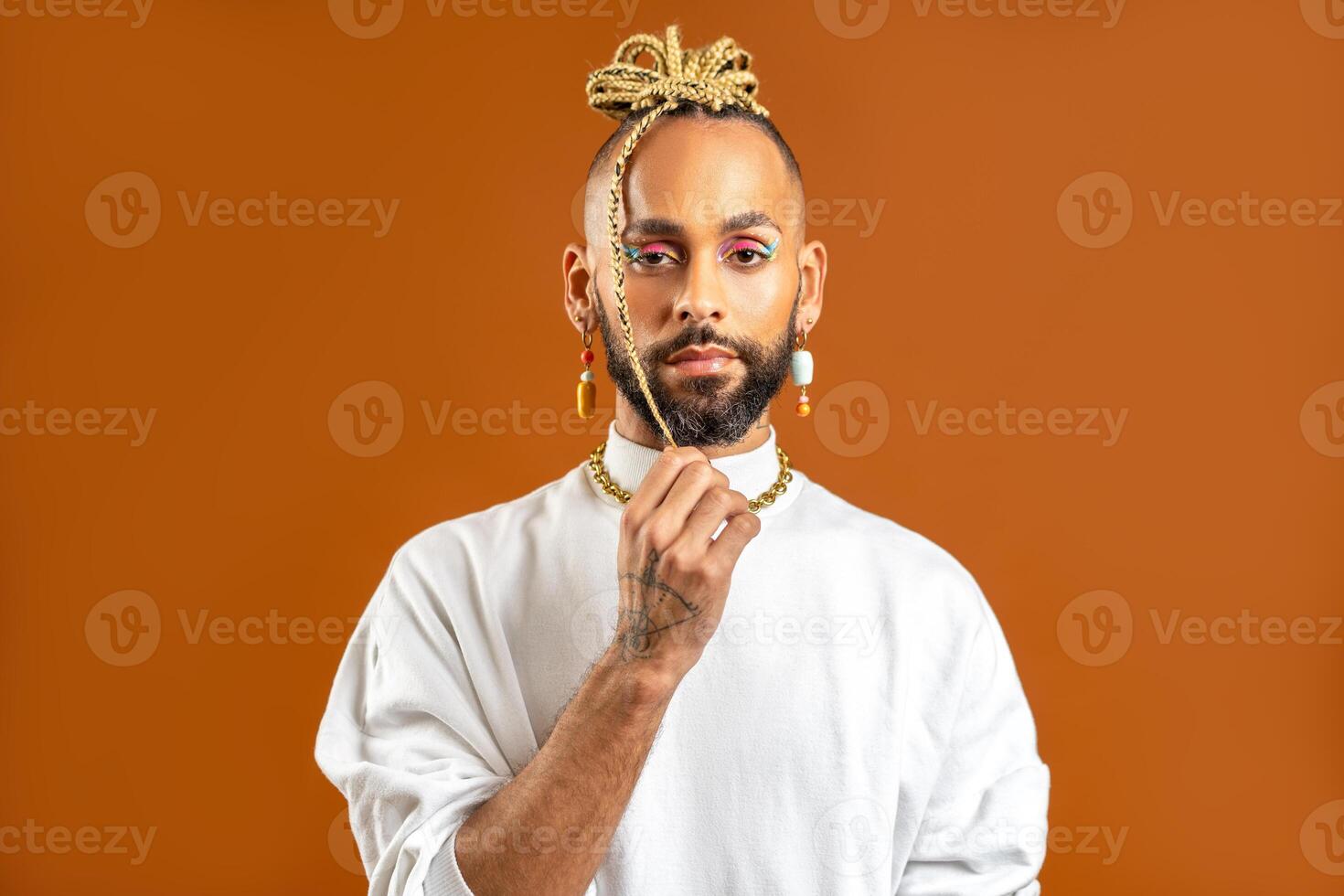 Black latin gay man with make up isolated on orange background photo