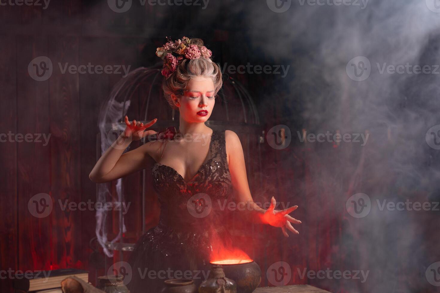 Víspera de Todos los Santos bruja con caldera. hermosa joven mujer prestidigitación, haciendo brujería foto