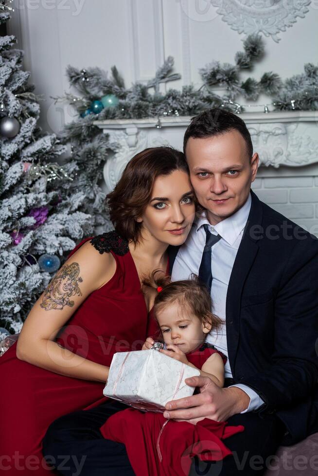 a man and woman in formal attire are holding a baby photo