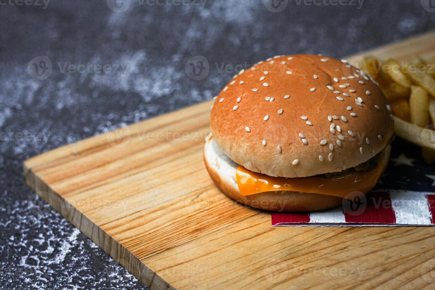 Cheese burger - American cheese burger with Golden French fries on wooden board photo