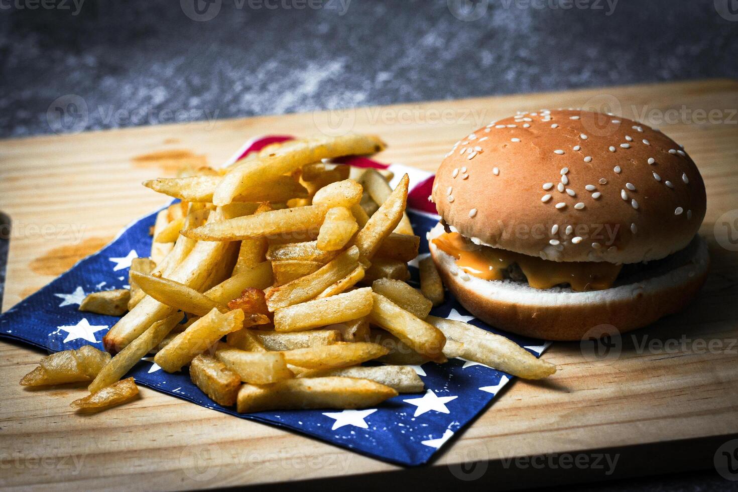 Cheese burger - American cheese burger with Golden French fries on wooden board photo