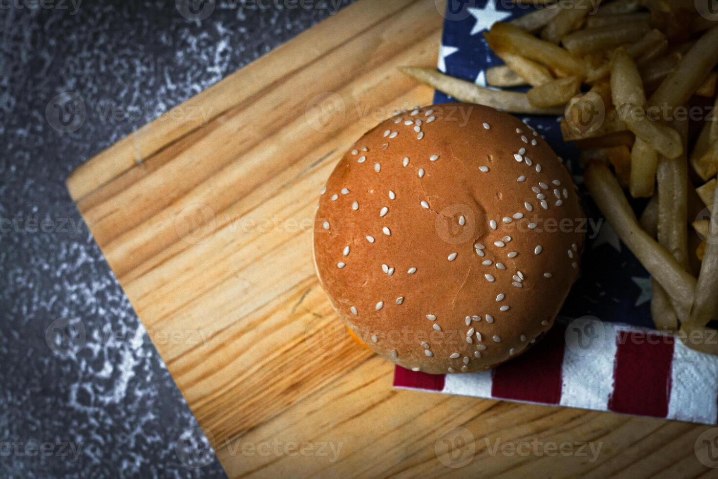Cheese burger - American cheese burger with Golden French fries on wooden board photo