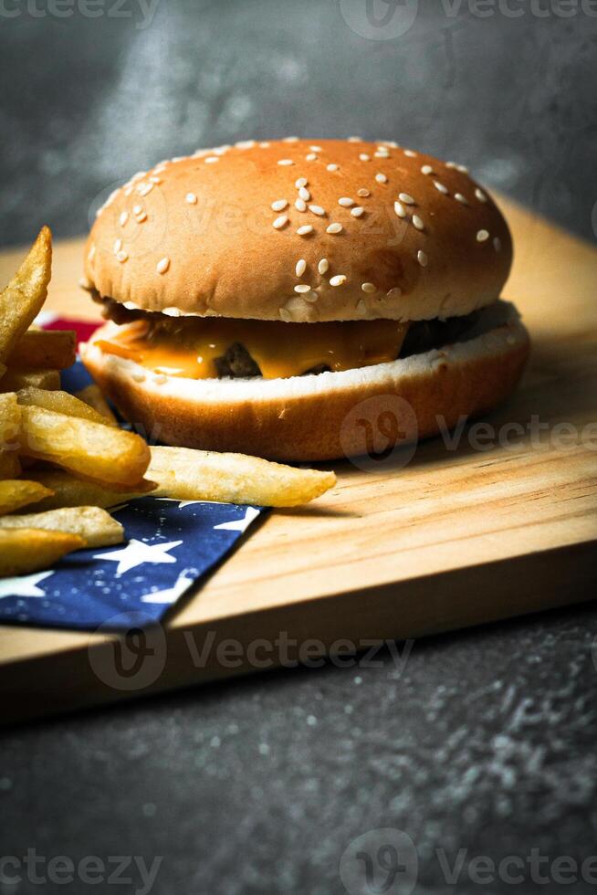 Cheese burger - American cheese burger with Golden French fries on wooden board photo