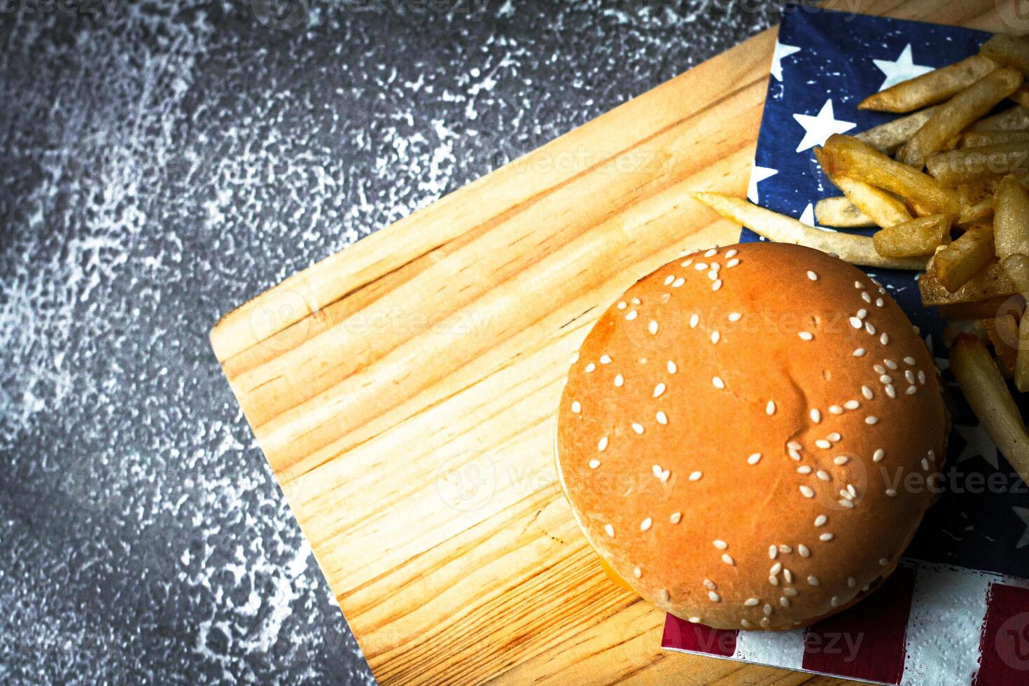 Cheese burger - American cheese burger with Golden French fries on wooden board photo