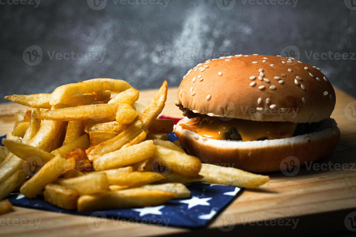 Cheese burger - American cheese burger with Golden French fries on wooden board photo