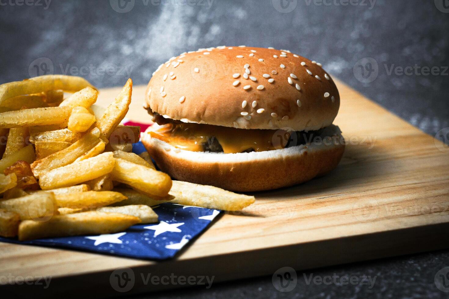 Cheese burger - American cheese burger with Golden French fries on wooden board photo