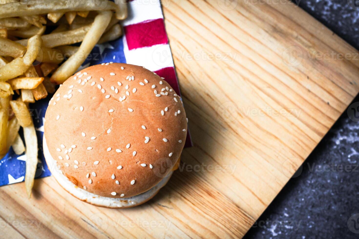 Cheese burger - American cheese burger with Golden French fries on wooden board photo