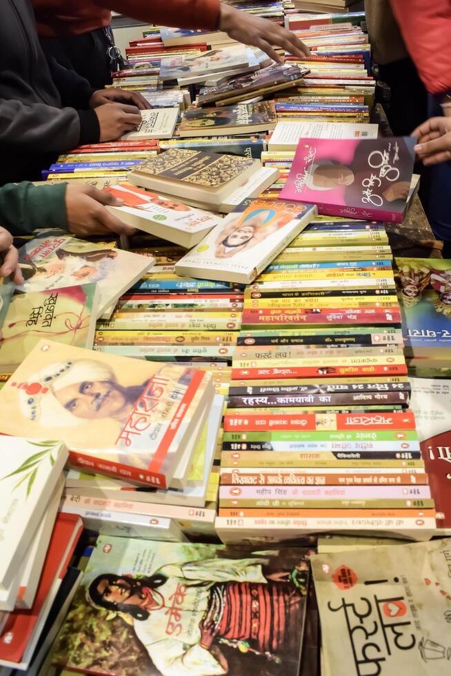 New Delhi, India, February 17 2024 - Variety of Books on shelf inside a book-stall at Delhi International Book Fair, Selection of books on display in Annual Book Fair at Bharat Mandapam complex photo