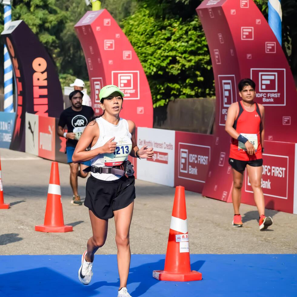 New Delhi, India - October 15 2023 - Vedanta Delhi Half Marathon race after covid in which marathon participants about to cross the finish line, Delhi Half Marathon 2023 photo