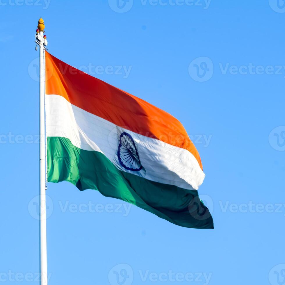 India flag flying high at Connaught Place with pride in blue sky, India flag fluttering, Indian Flag on Independence Day and Republic Day of India, tilt up shot, Waving Indian flag, Har Ghar Tiranga photo